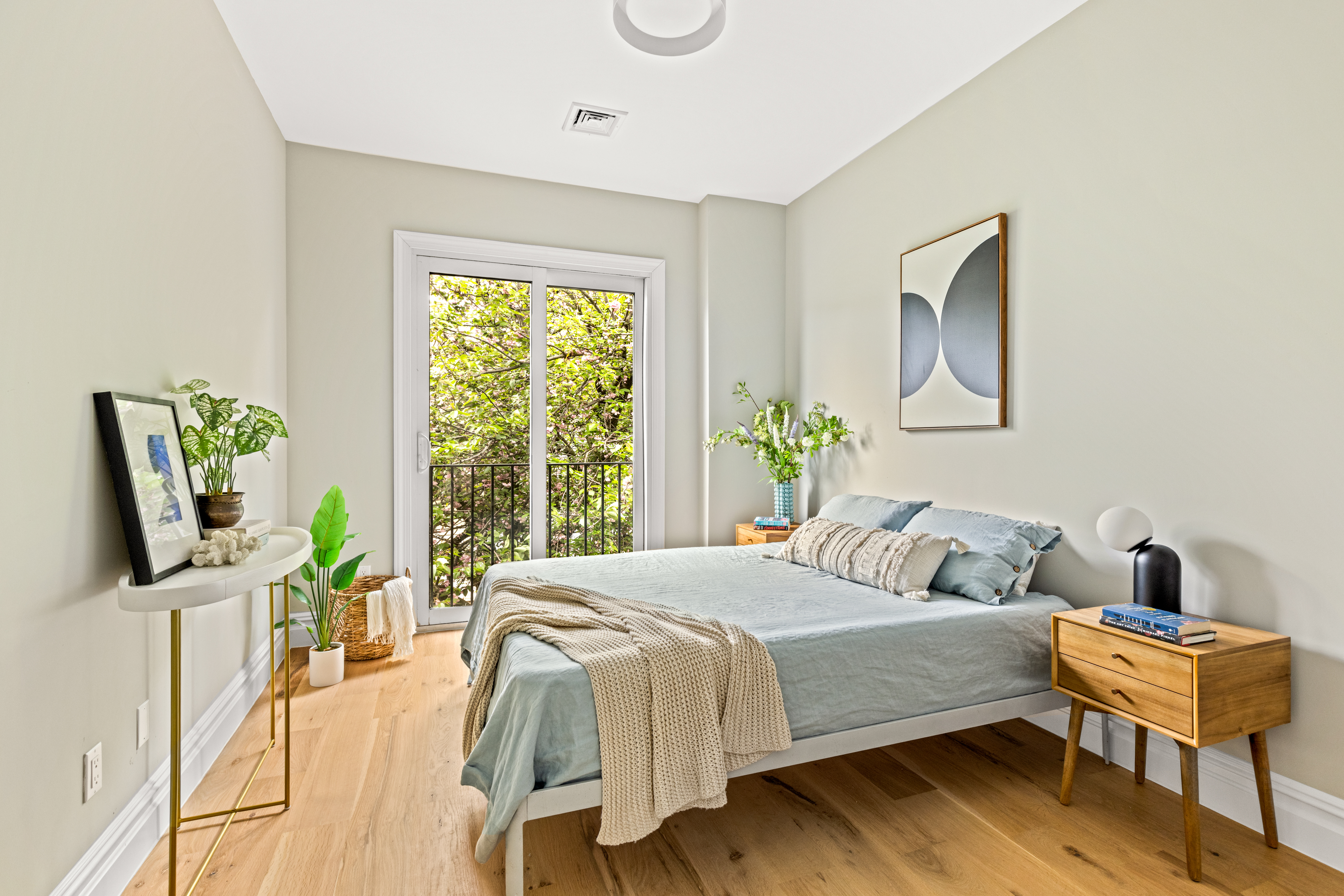 409 East 4th Street Brooklyn, NY 11218 - Photo 4 of 19 a bedroom with a bed a flat tv screen and a potted plant