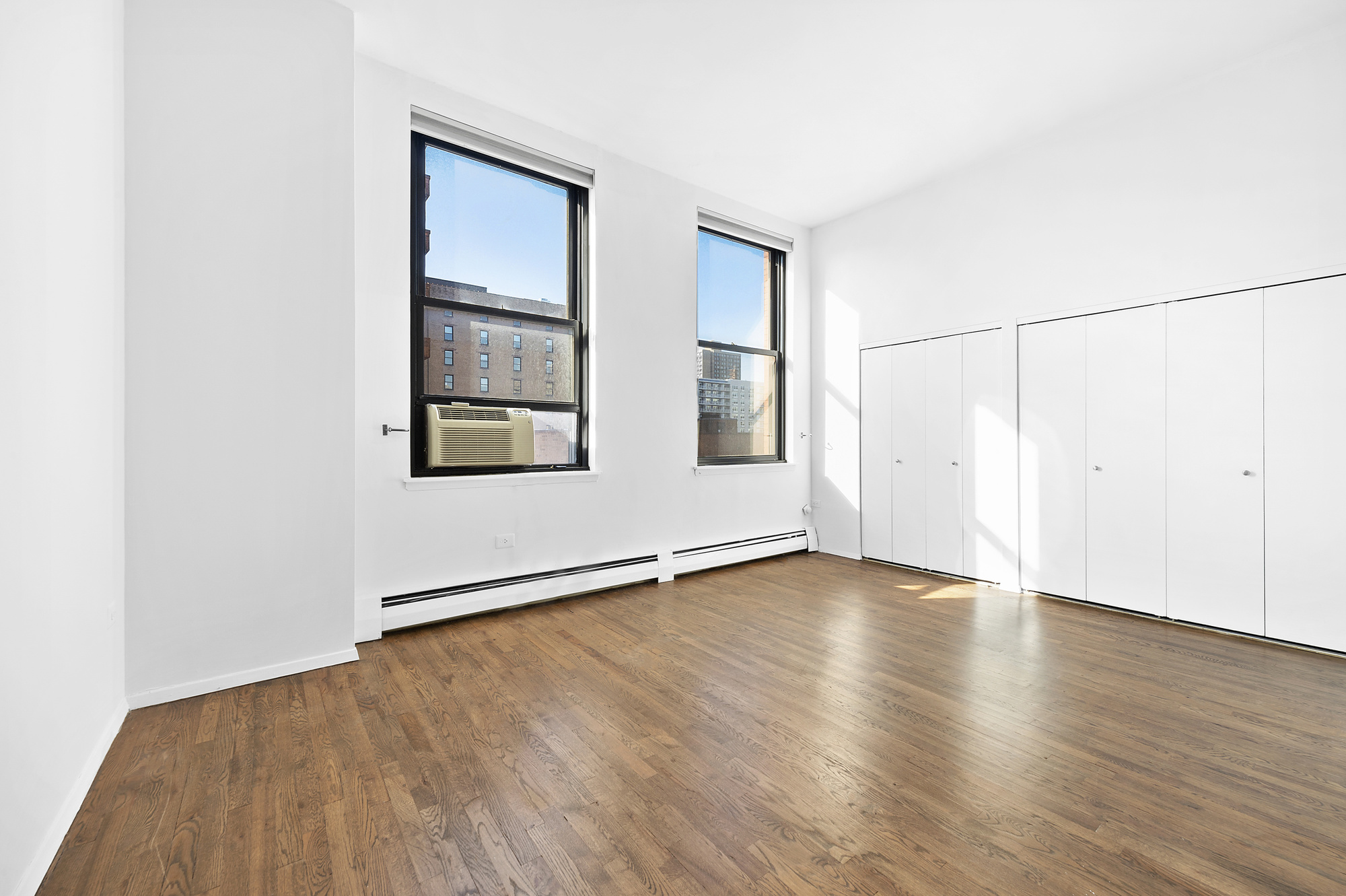 250 Mercer Street, Unit D603 Manhattan, NY 10012 - Photo 7 of 20 an empty room with wooden floor and windows