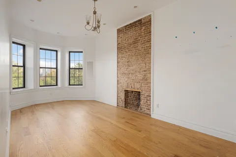 an empty room with windows and fireplace