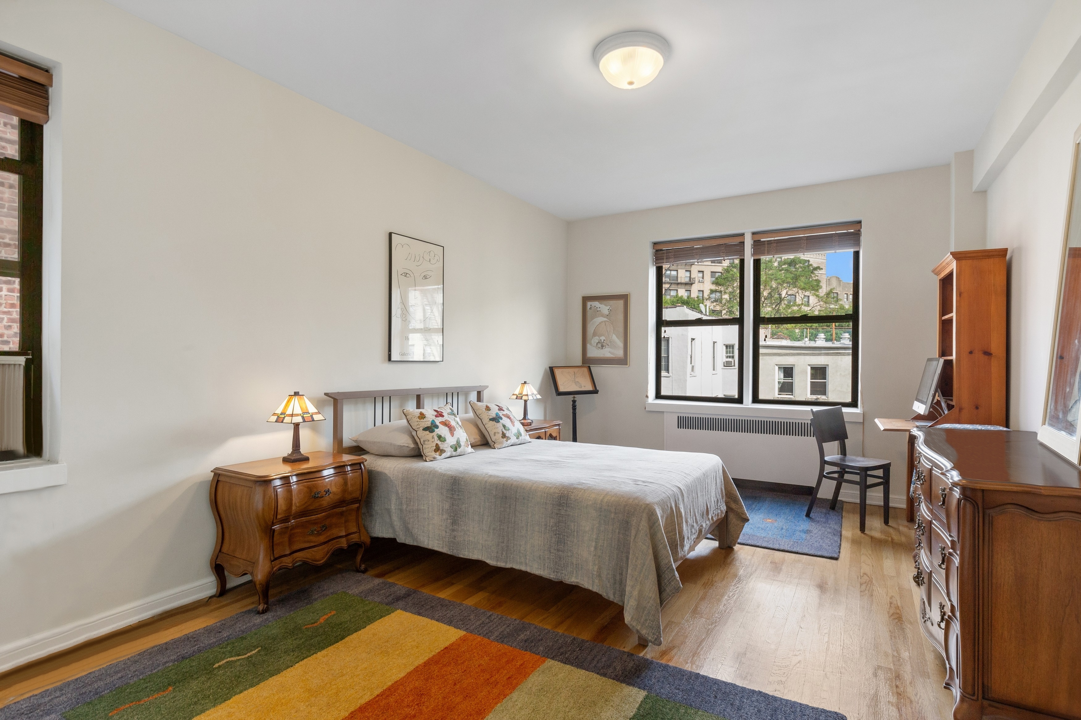 159-00 Riverside Drive West, Unit 5D Manhattan, NY 10032 - Photo 6 of 19 a bedroom with a bed wooden floor and windows