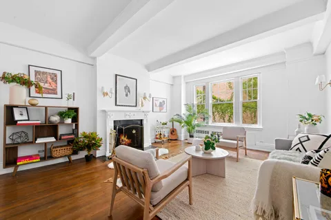 a living room with furniture a fireplace and a large window