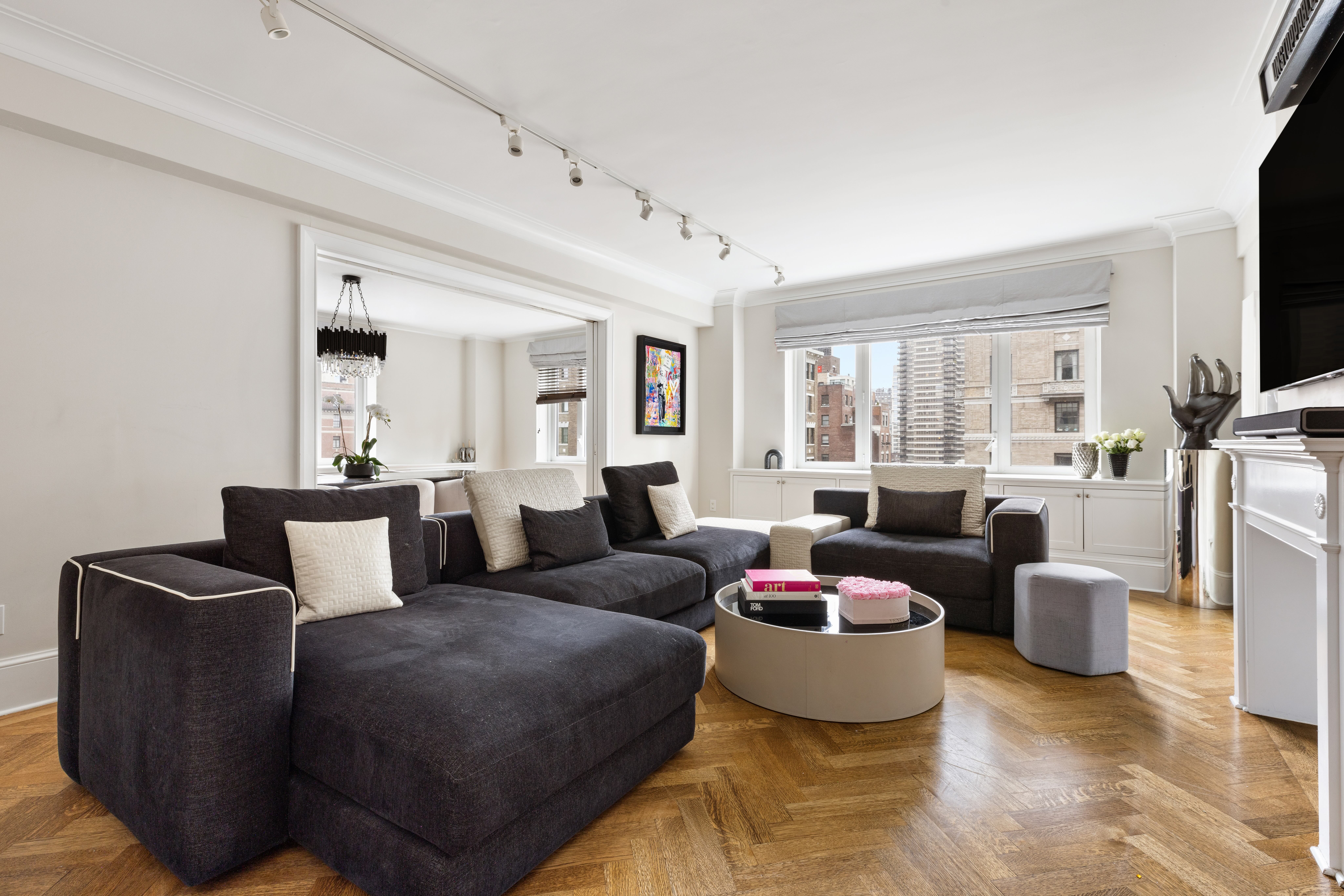 a living room with furniture a flat screen tv and a window
