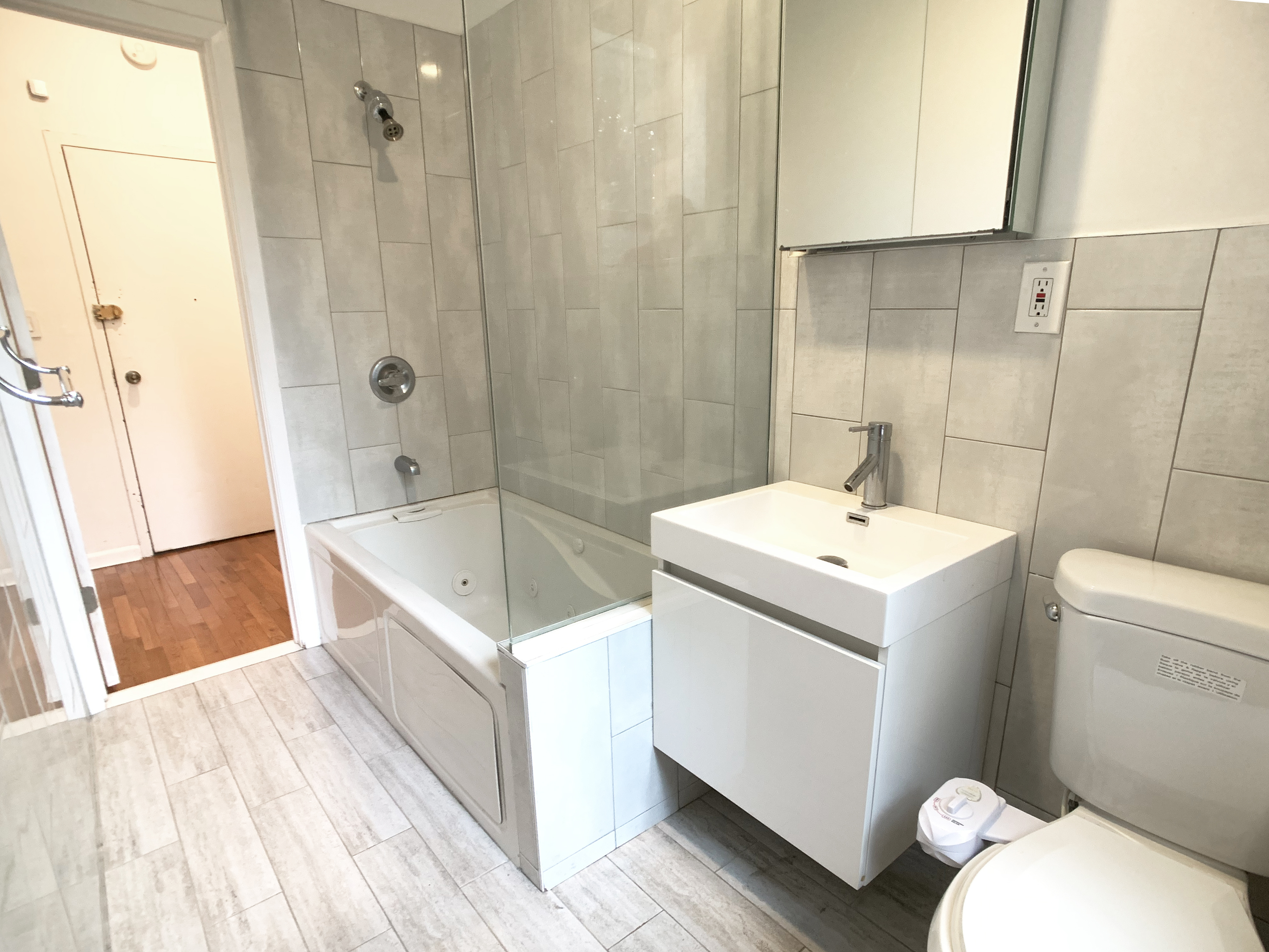 293 Tompkins Avenue, Unit 2 Brooklyn, NY 11221 - Photo 8 of 11 a bathroom with a sink toilet and shower