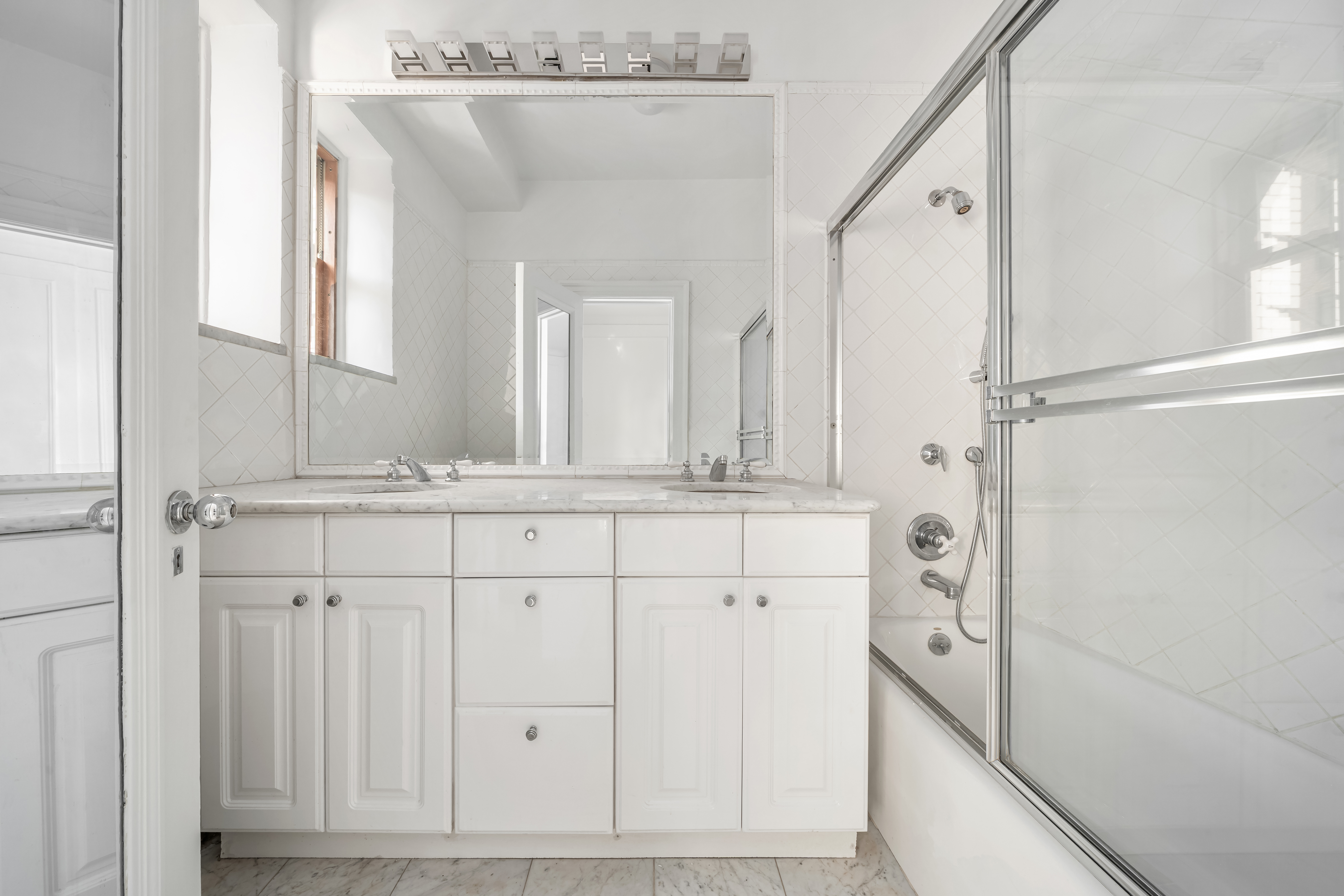 225 West 86th Street, Unit 301 Manhattan, NY 10024 - Photo 6 of 7 a bathroom with a double vanity sink mirror and