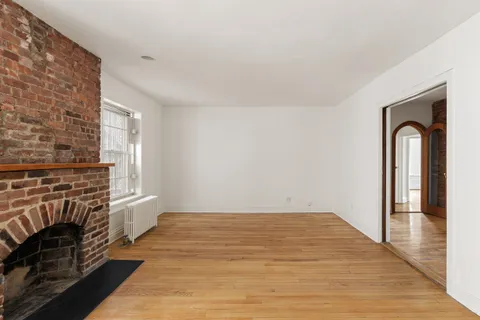 wooden floor fireplace and windows in an empty room