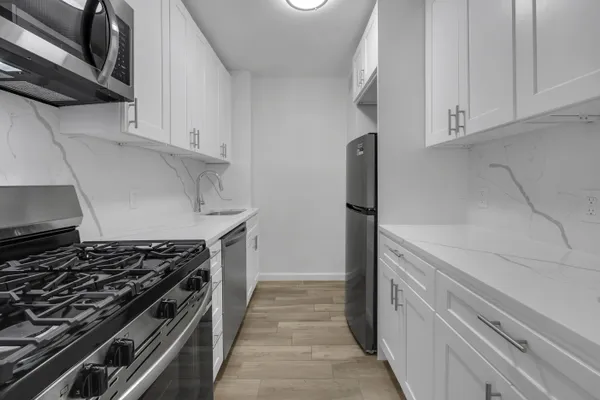a kitchen with white cabinets and appliances