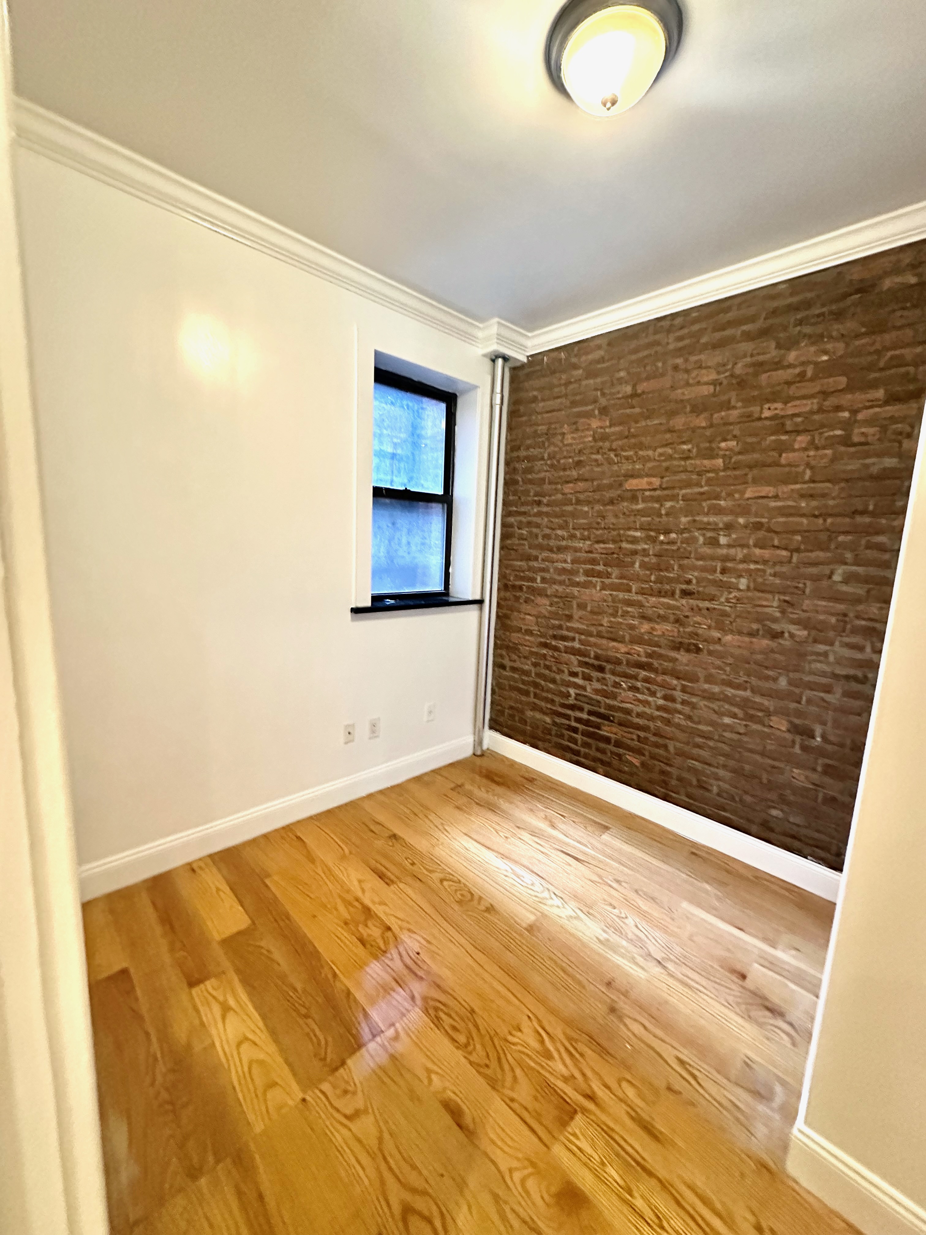 541 West 144th Street, Unit 4 Manhattan, NY 10031 - Photo 8 of 9 a view of empty room with wooden floor