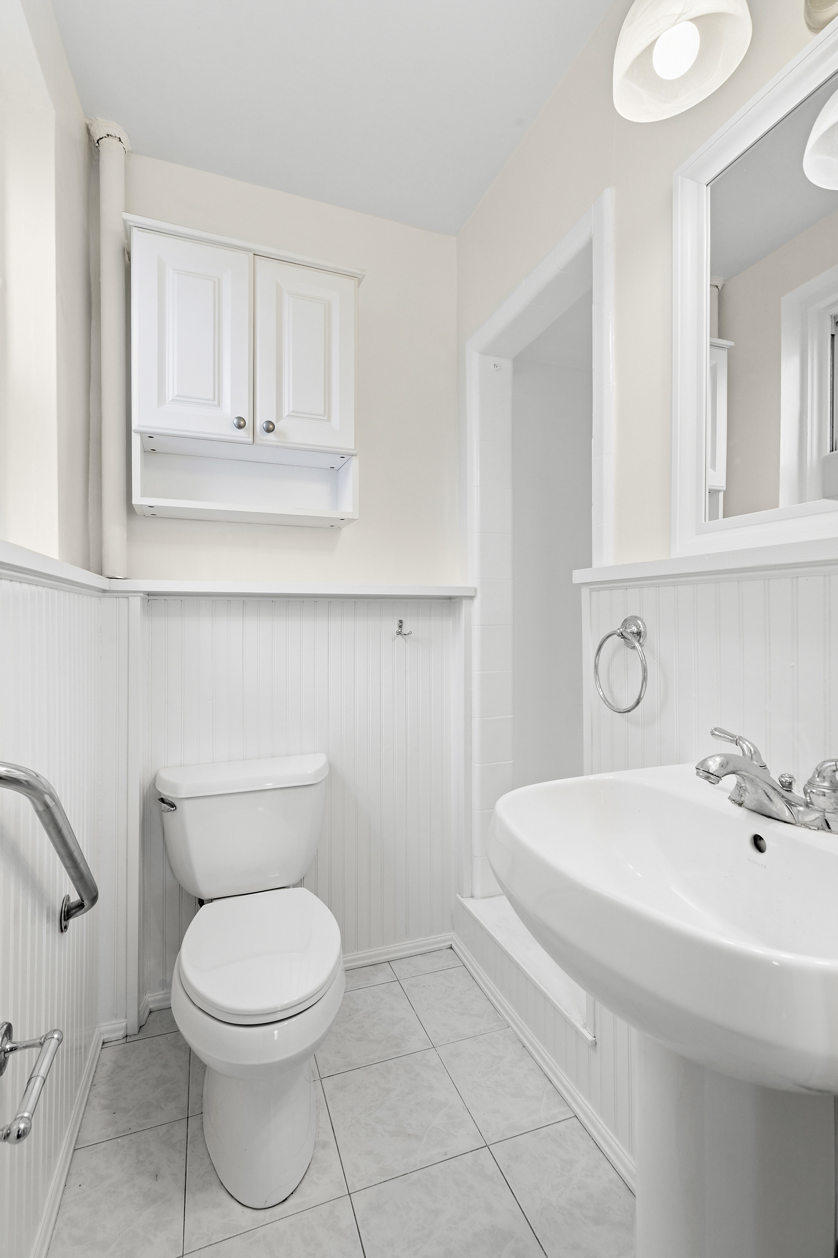 9801 Shore Road, Unit 1K Brooklyn, NY 11209 - Photo 9 of 11 a bathroom with a toilet a sink and mirror