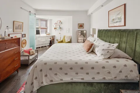 a bedroom with a bed and wooden floor