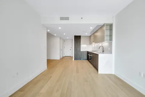 a view of a kitchen with a sink and wooden cabinet
