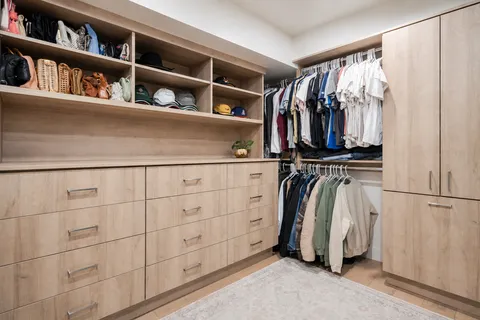 a view of walk in closet with clothes and shoes