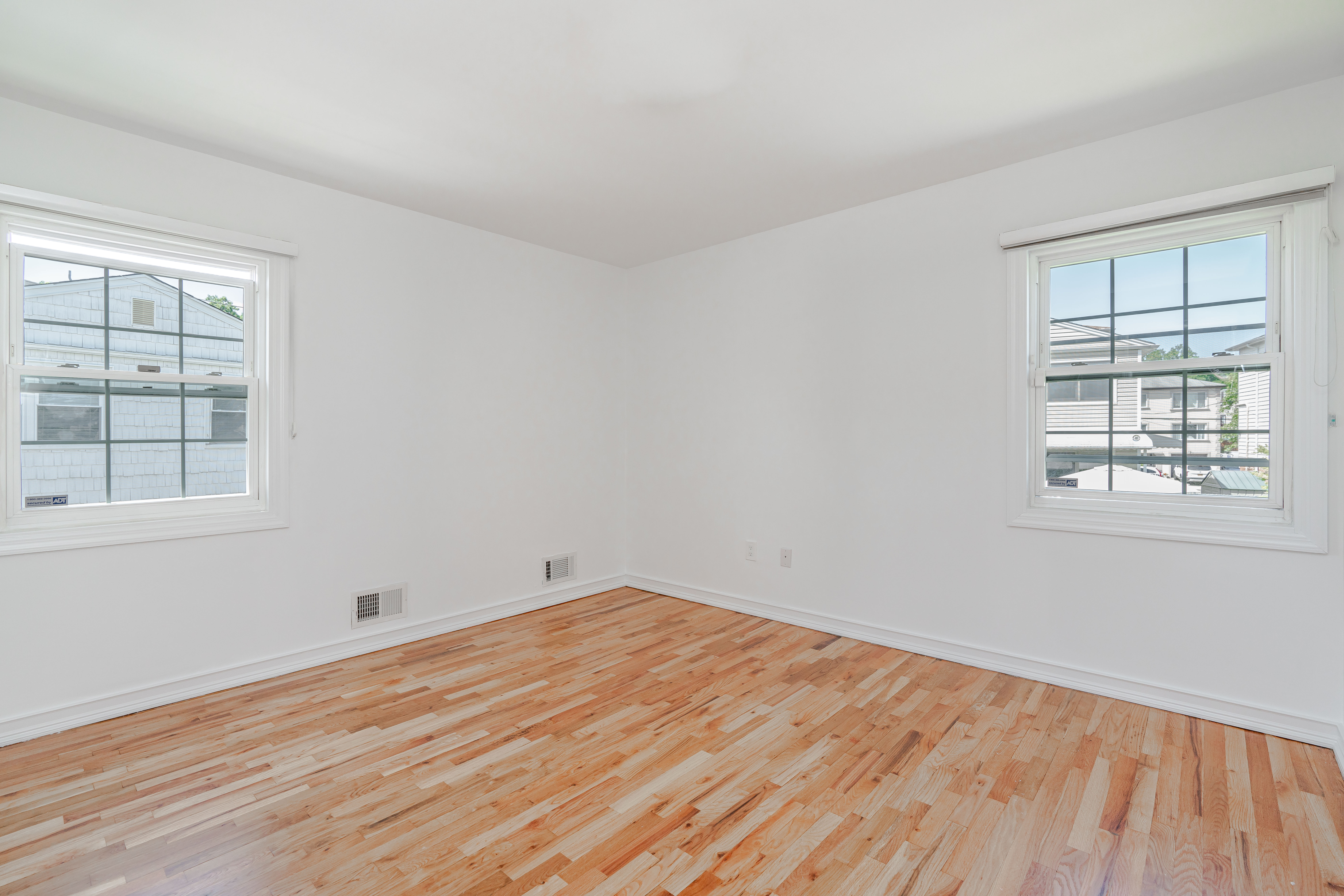 15-80 209th Street, Unit 2 Queens, NY 11360 - Photo 8 of 11 a view of empty room with wooden floor and fan