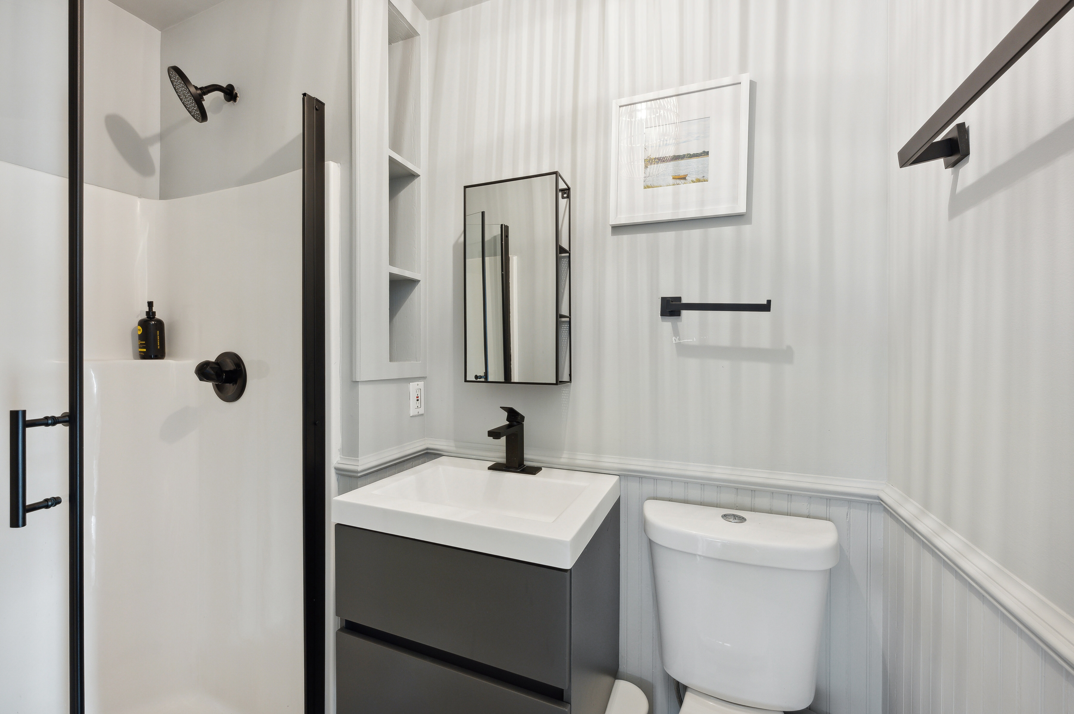 32 Lighthouse Road Hampton Bays, NY 11946 - Photo 49 of 51 a bathroom with a toilet sink and mirror