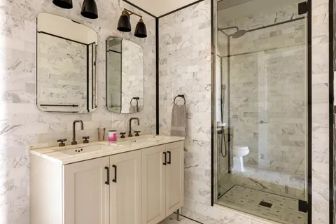a bathroom with a shower sink and mirror