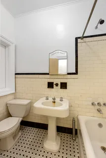 a bathroom with a sink toilet a mirror and bathtub