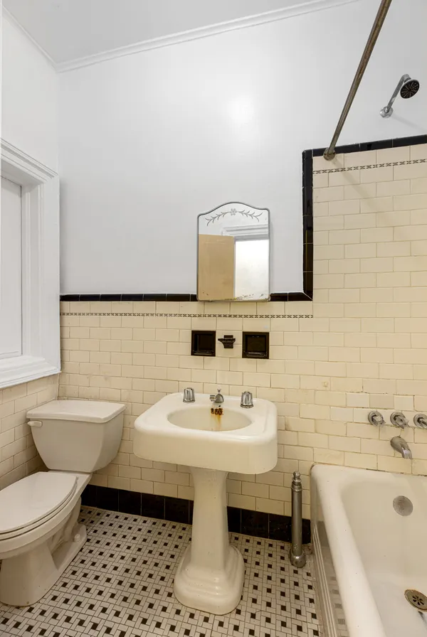 a bathroom with a sink toilet a mirror and bathtub