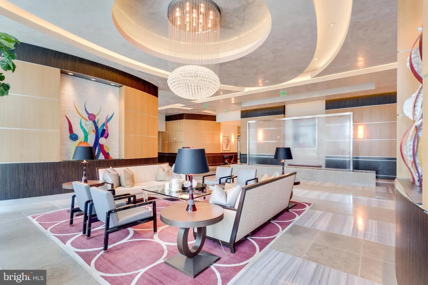 a living room with furniture a chandelier and a large window