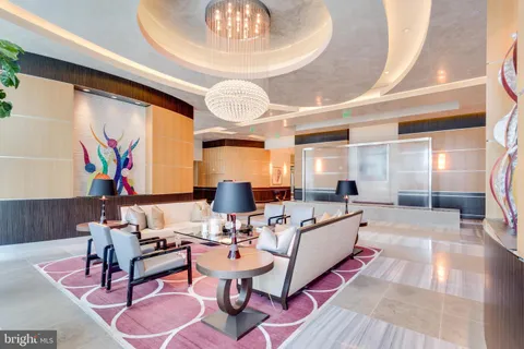 a living room with furniture a chandelier and a large window