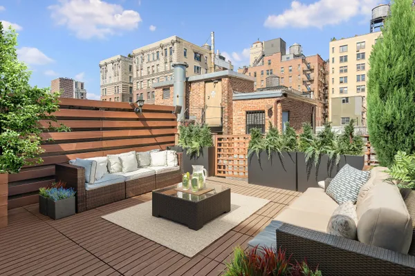 a view of a balcony with chairs and a potted plant
