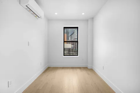 an empty room with a window and wooden floor