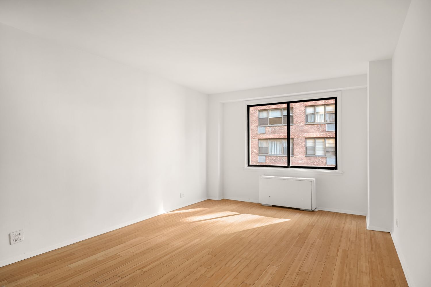 345 East 73rd Street, Unit 3A Manhattan, NY 10021 - Photo 3 of 7 an empty room with wooden floor and windows