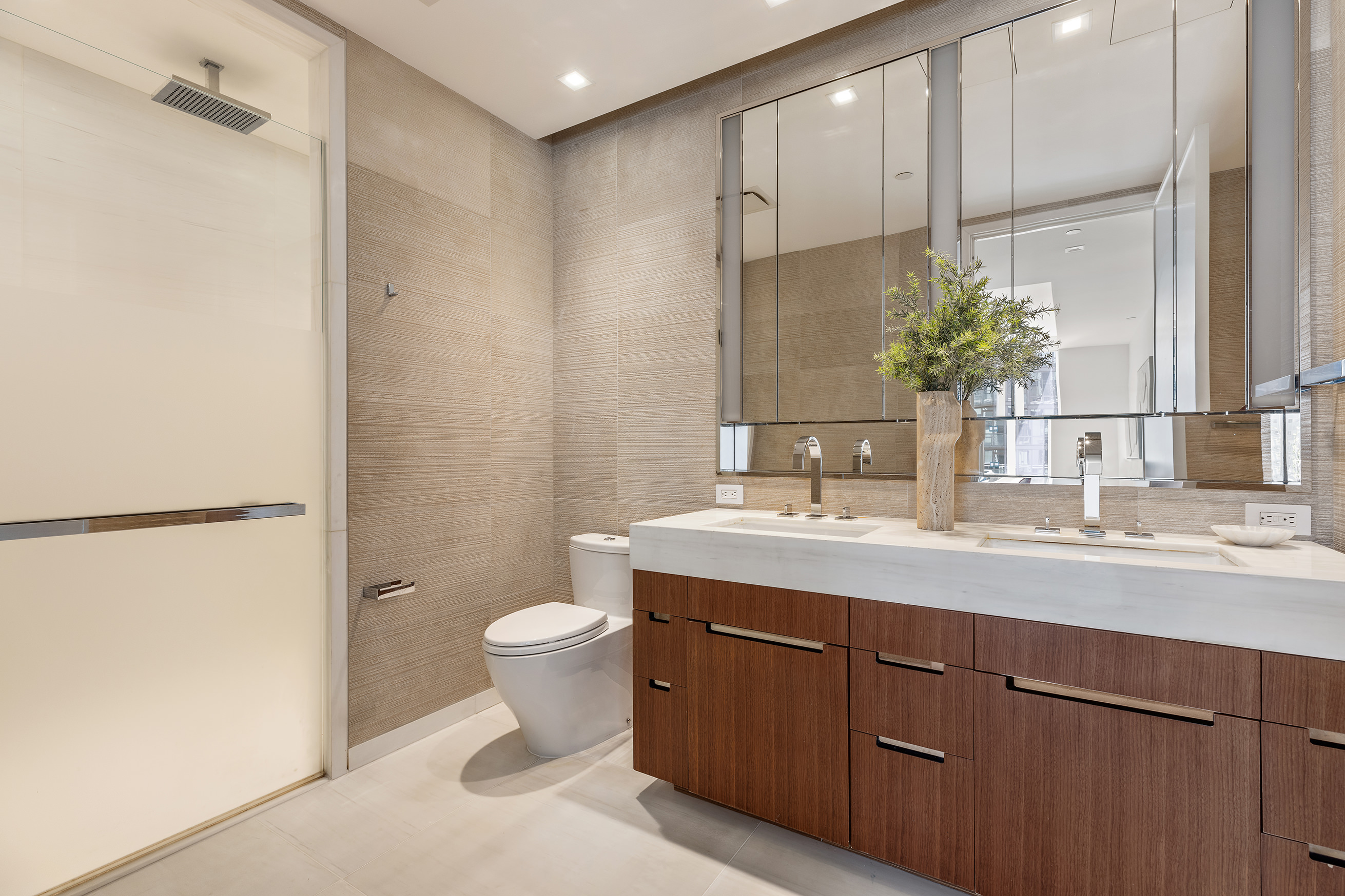 1 West End Avenue, Unit 15E Manhattan, NY 10023 - Photo 7 of 31 a bathroom with a granite countertop sink a toilet and a mirror