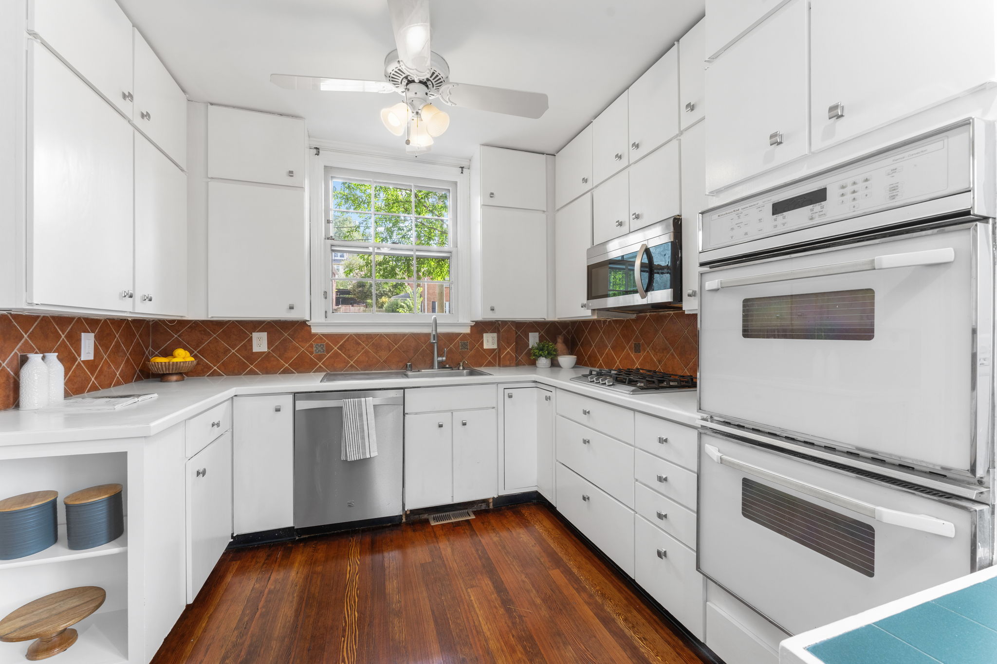 1325 Locust Road Northwest Washington, DC 20012 - Photo 20 of 56 a kitchen with stainless steel appliances white cabinets and window