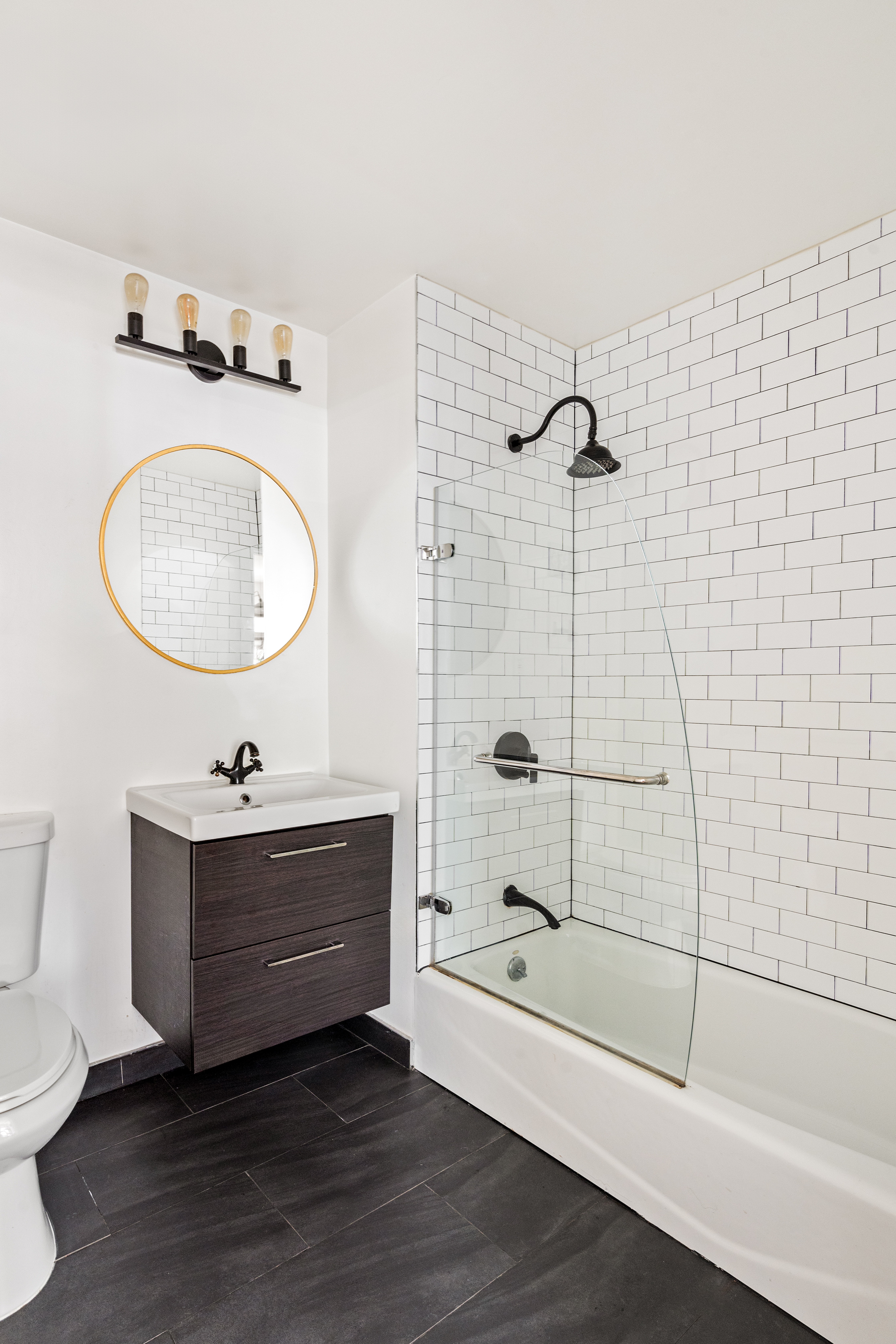 319 Humboldt Street, Unit 1A Brooklyn, NY 11211 - Photo 6 of 10 a bathroom with a tub sink toilet and mirror