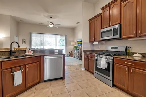 a living room with furniture kitchen view and a wooden floor