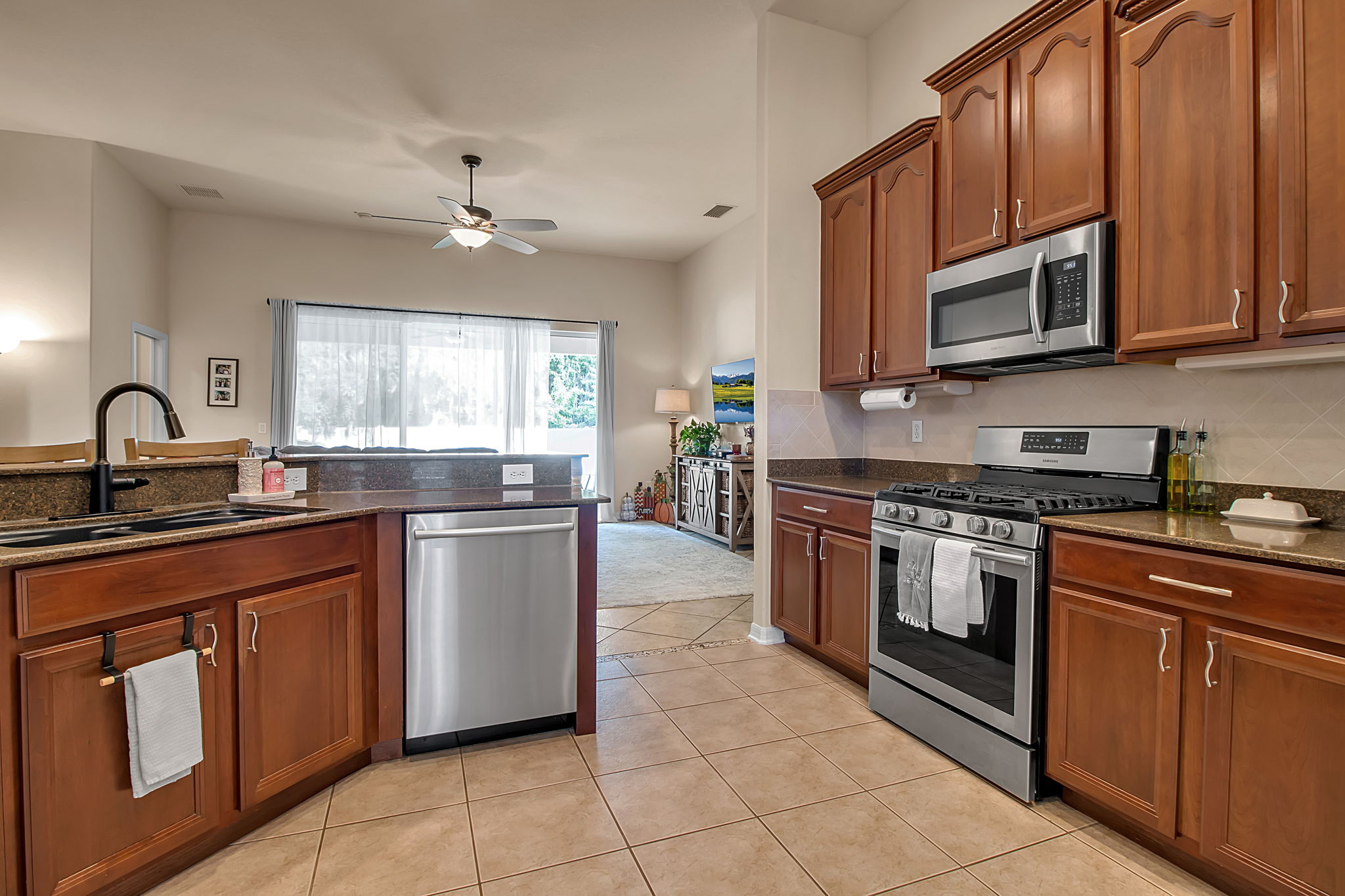 6106 34th Court East Bradenton, FL 34203 - Photo 24 of 69 a kitchen with stainless steel appliances granite countertop a stove top oven a sink dishwasher and a microwave oven with cabinets