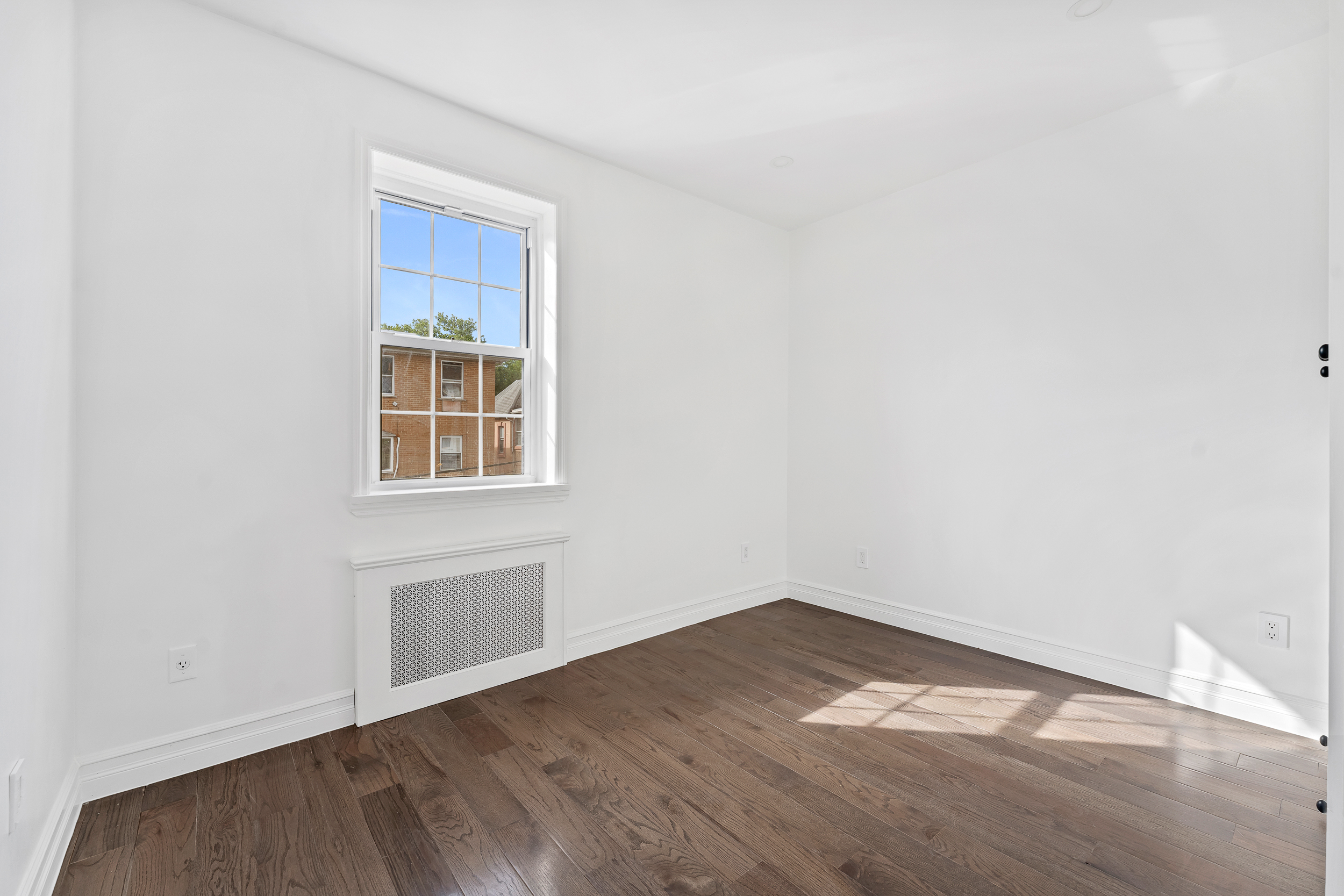 65 Bay 23rd Street, Unit 2 Brooklyn, NY 11214 - Photo 10 of 16 a view of empty room with wooden floor and fan