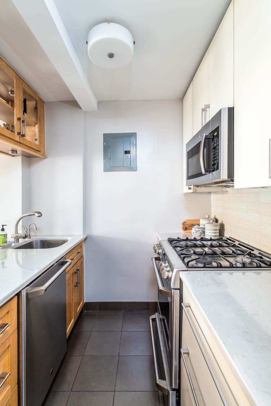 415 East 85th Street, Unit 5J Manhattan, NY 10028 - Photo 9 of 19 a kitchen with stainless steel appliances granite countertop a sink and a stove