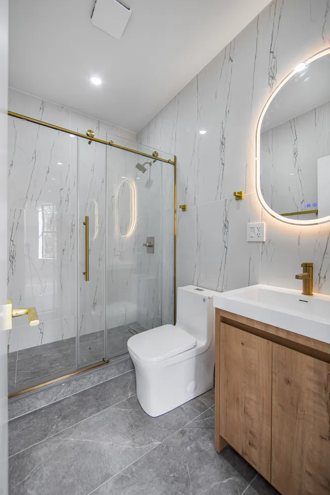 a bathroom with a sink a toilet and shower