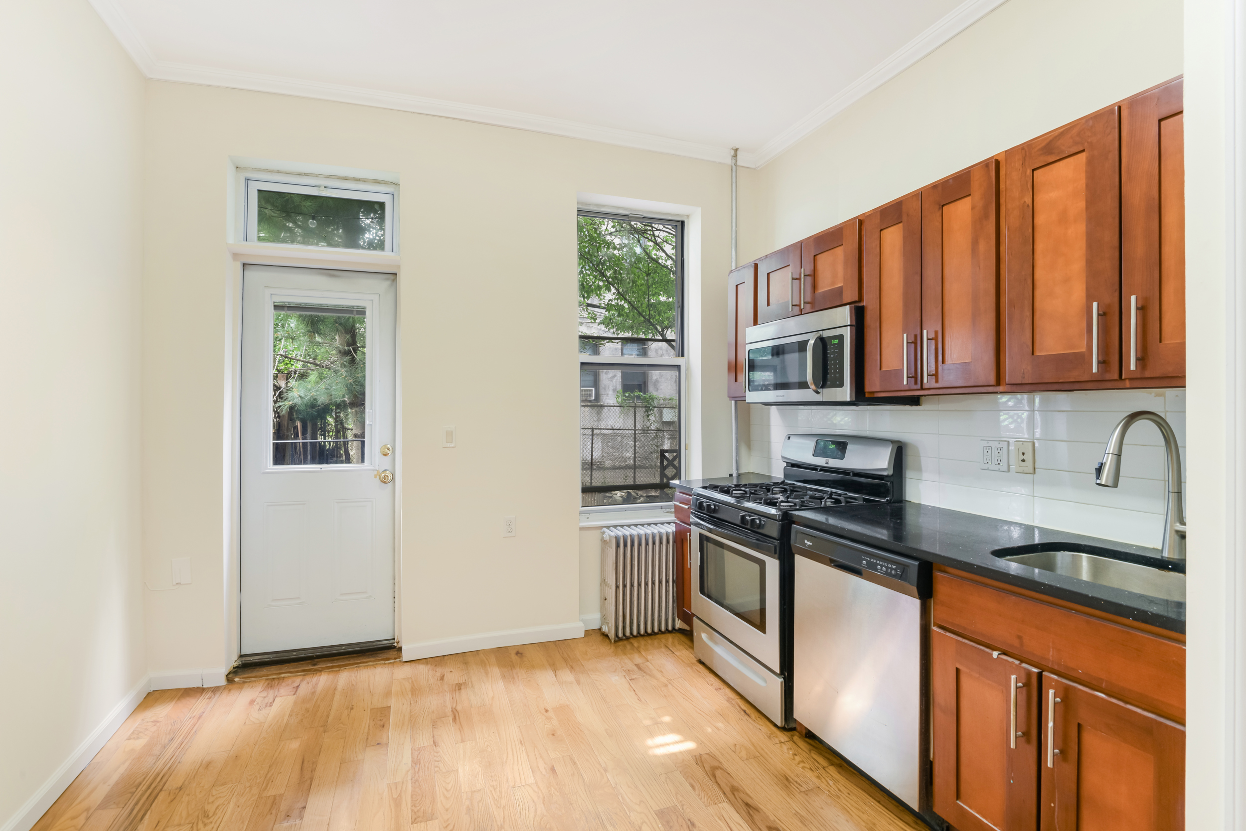 262 12th Street, Unit 1L Brooklyn, NY 11215 - Photo 3 of 10 a kitchen with stainless steel appliances granite countertop a stove a sink and a microwave
