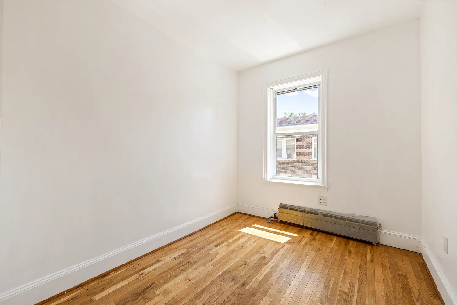 a view of a room with wooden floor and window