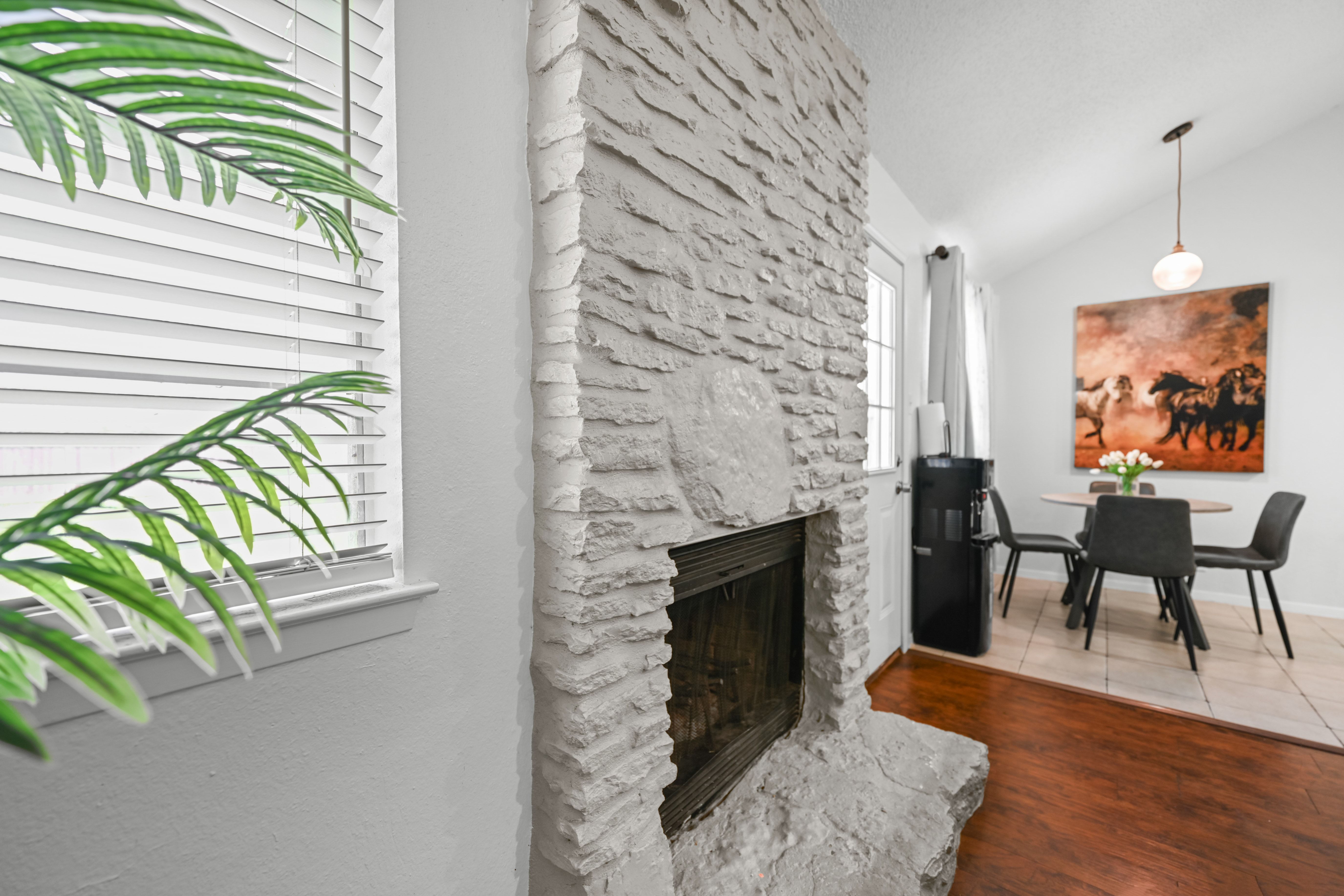 8710 Clearbrook Trail Austin, TX 78729 - Photo 19 of 28 a living room with furniture a fireplace and a floor to ceiling window