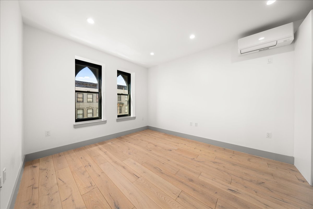 463 West 142nd Street, Unit 4B Manhattan, NY 10031 - Photo 4 of 10 an empty room with windows and ceiling fan