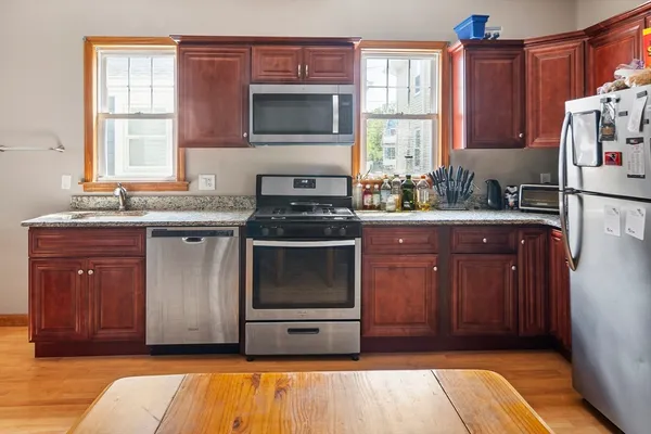a kitchen with stainless steel appliances granite countertop a stove a sink and a microwave