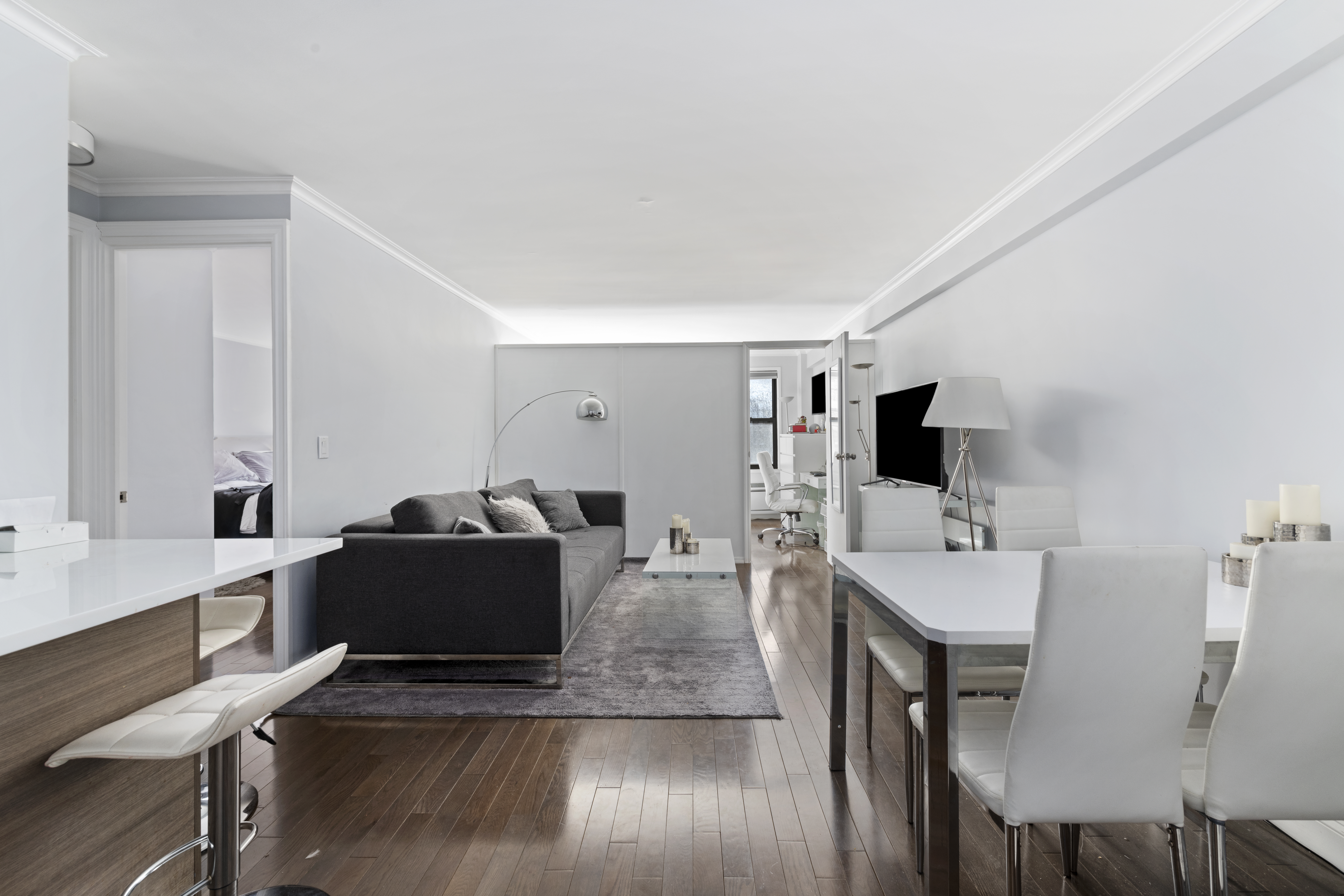 333 East 34th Street, Unit 10H Manhattan, NY 10016 - Photo 2 of 16 a living room with furniture a flat screen tv and kitchen view