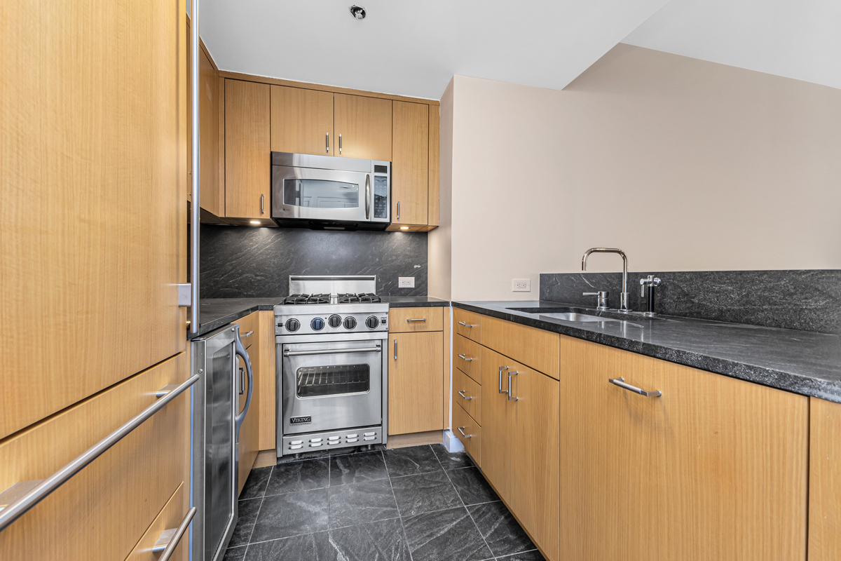 100 West 58th Street, Unit 12A Manhattan, NY 10019 - Photo 2 of 15 a kitchen with a sink and a stove