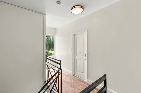 a view of a hallway with wooden floor and staircase