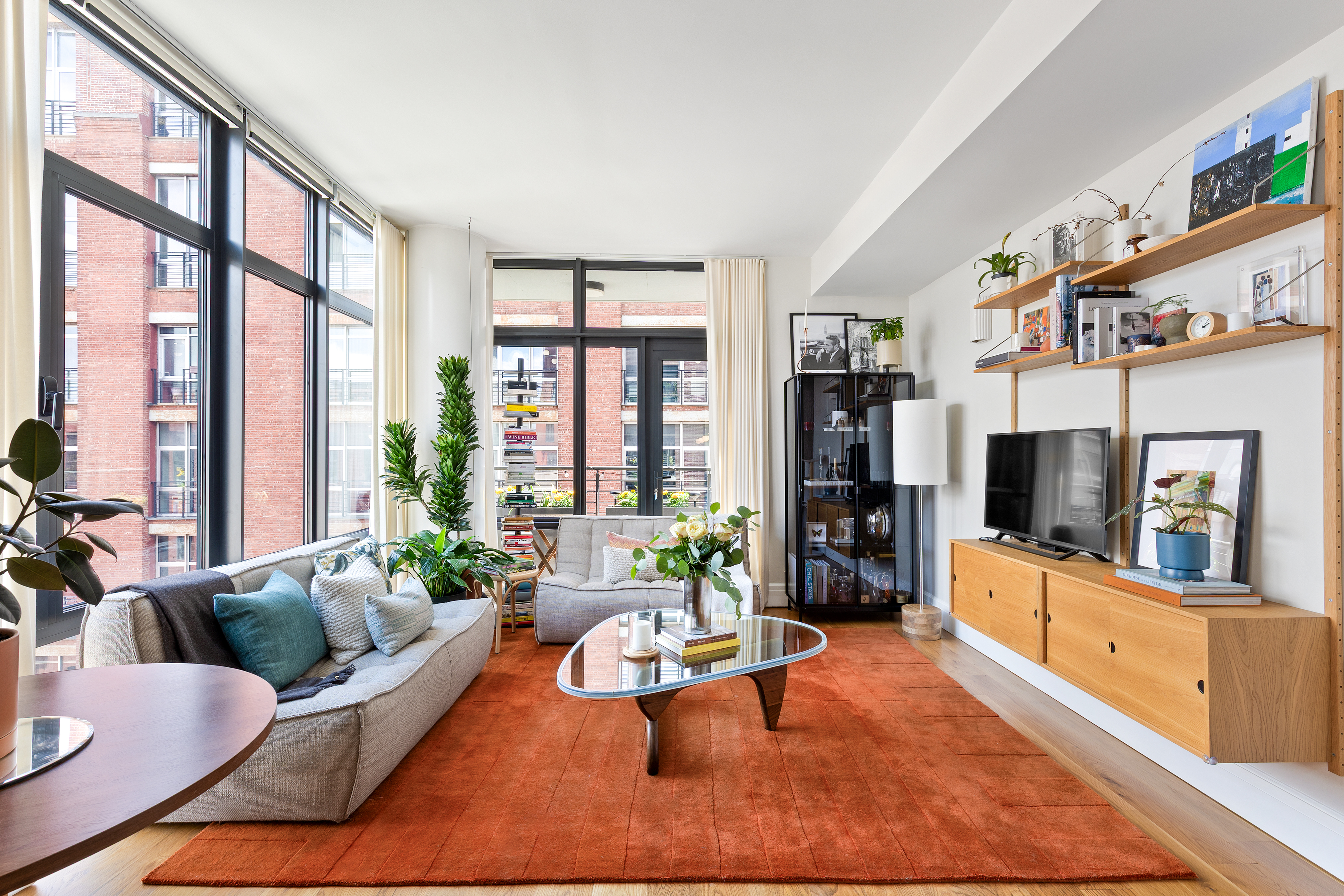 a living room with furniture large window and flat screen tv