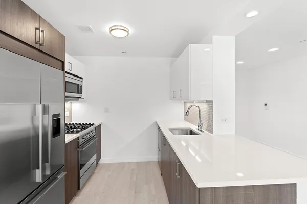 a kitchen with stainless steel appliances granite countertop a sink refrigerator and microwave
