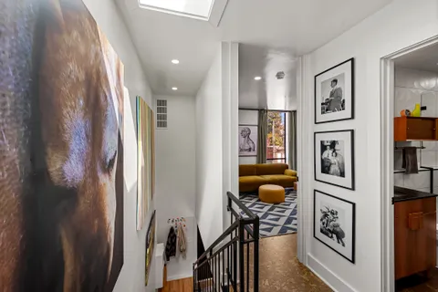 a hallway with table and painting on the wall