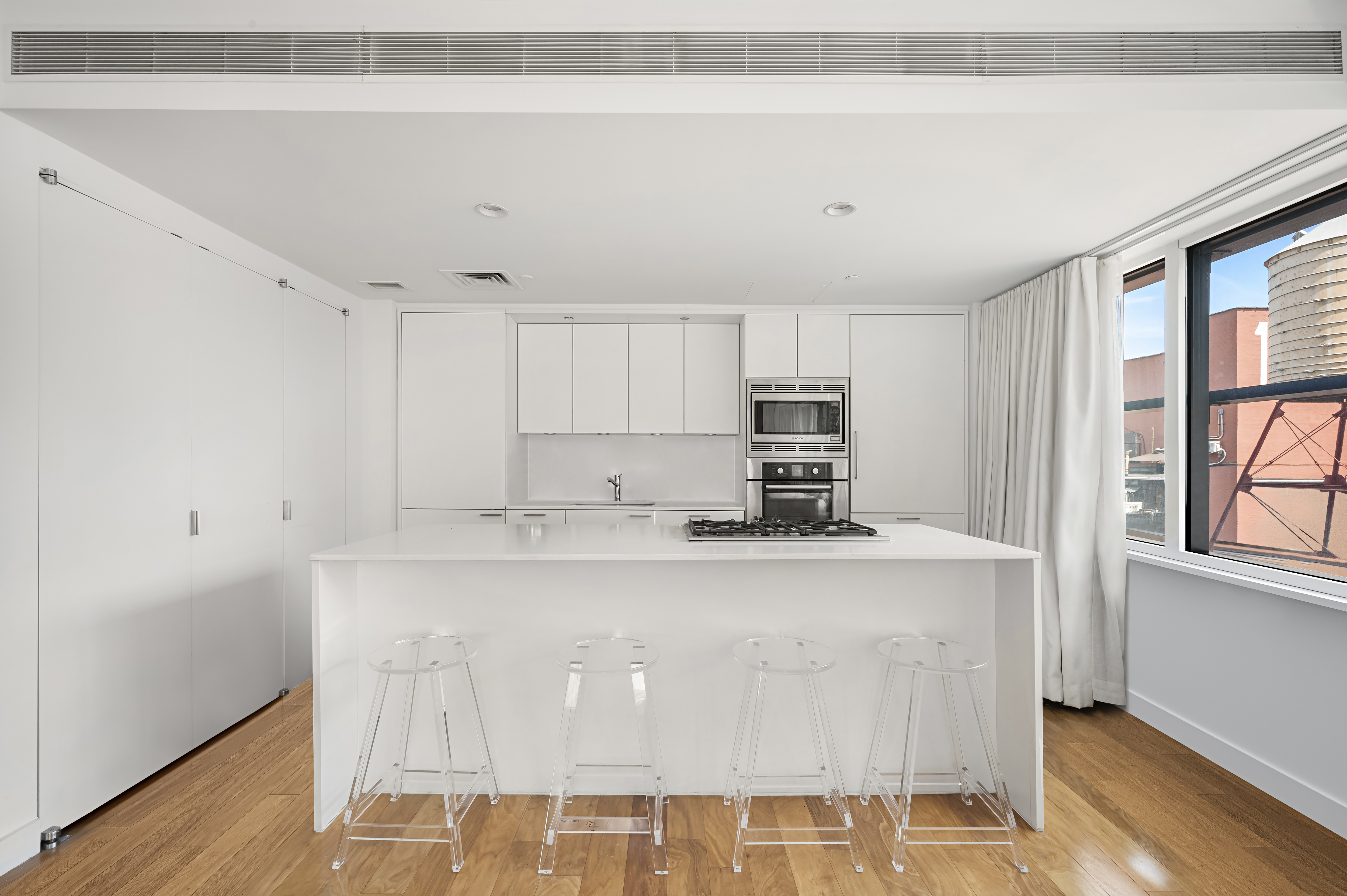84 White Street, Unit 11D Manhattan, NY 10013 - Photo 3 of 6 a view of kitchen with stainless steel appliances granite countertop cabinets and wooden floor