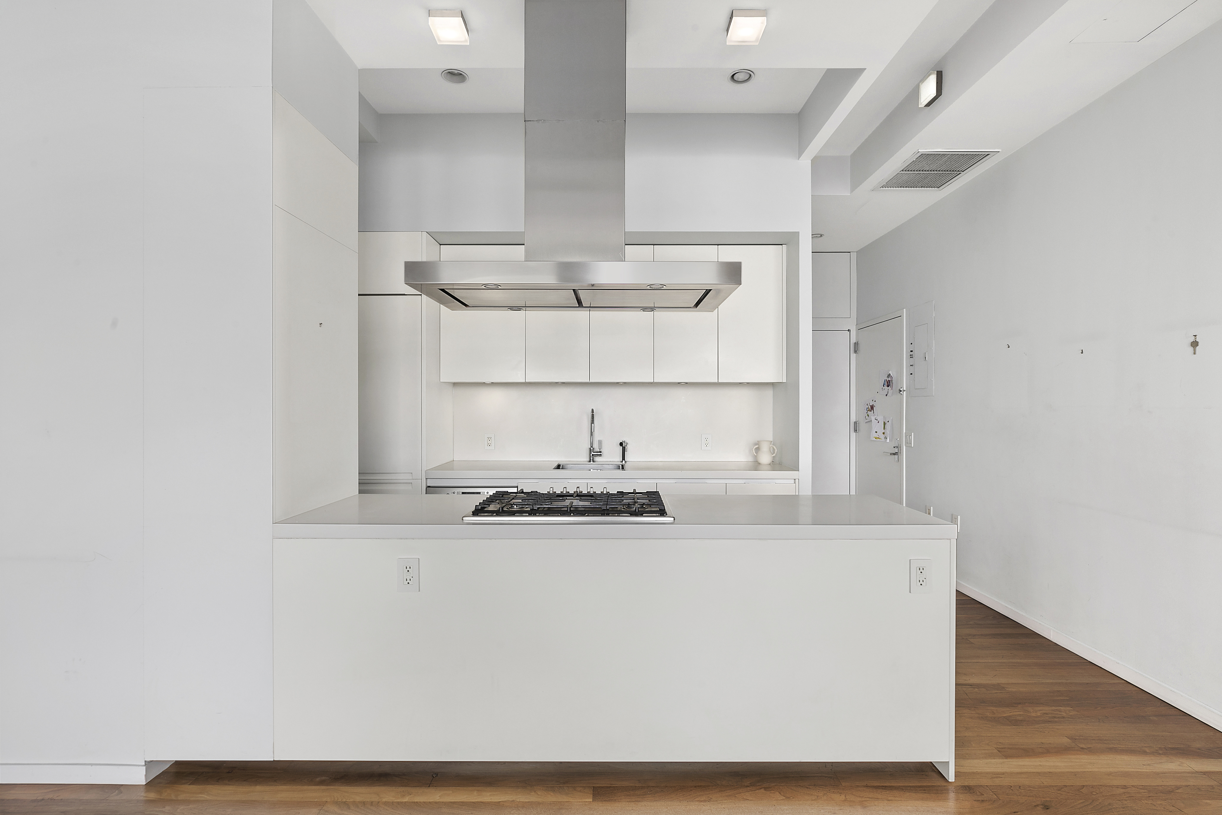 175 East Broadway, Unit 7A Manhattan, NY 10002 - Photo 5 of 9 a close view of kitchen countertops with wooden floor and cabinets