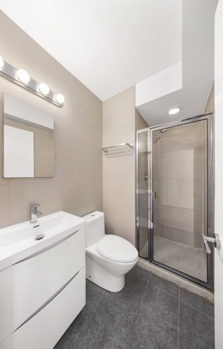 300 East 93rd Street, Unit 18E Manhattan, NY 10128 - Photo 6 of 15 a bathroom with a toilet a sink and shower
