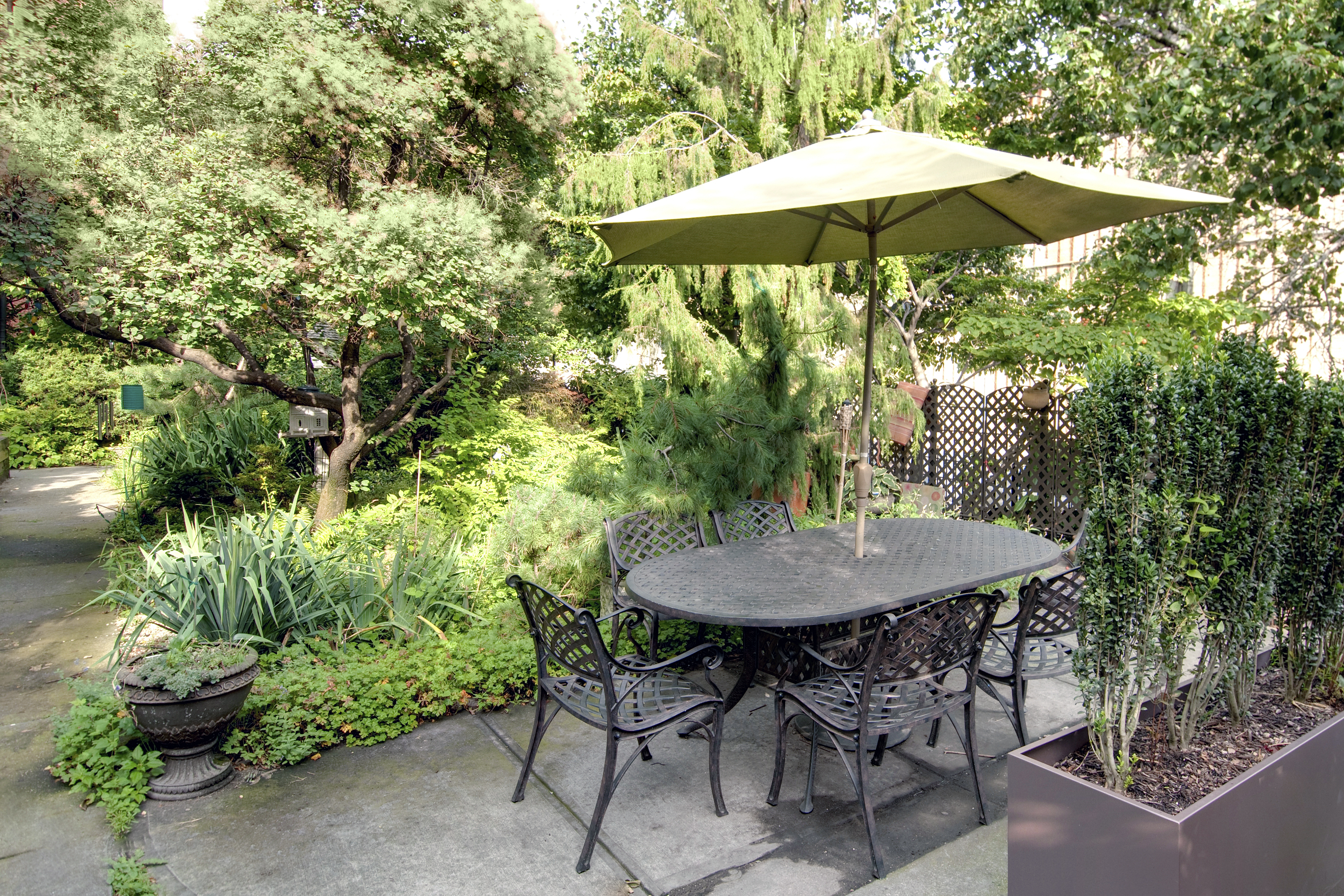 55 Poplar Street, Unit 4K Brooklyn, NY 11201 - Photo 14 of 15 a backyard of a house with table and chairs under an umbrella