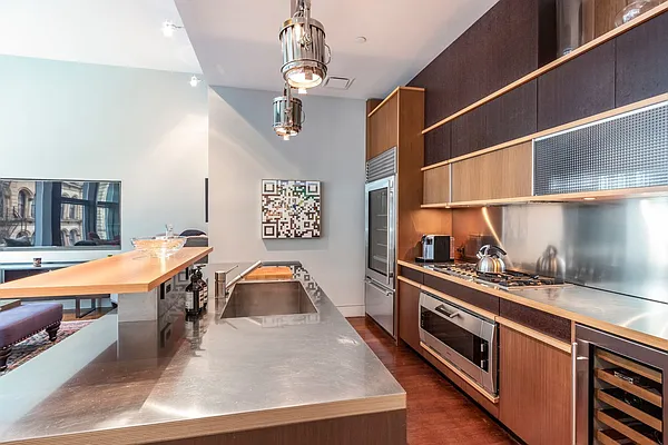 a kitchen with stainless steel appliances granite countertop a sink a stove and a wooden floors