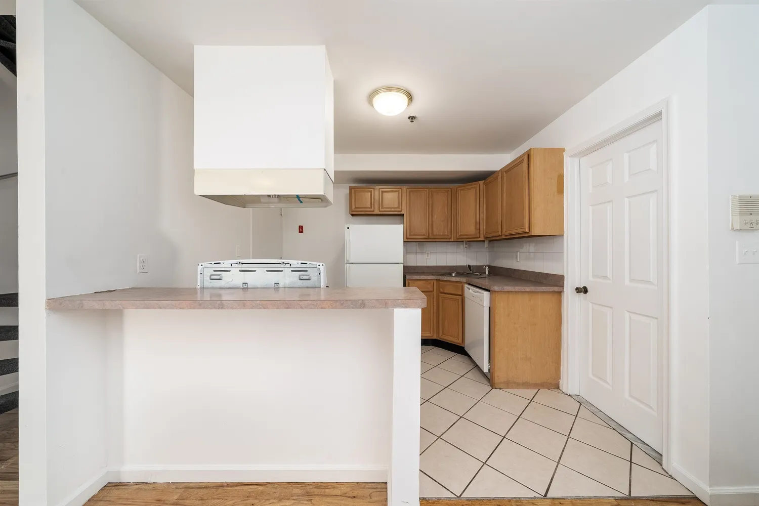 a kitchen with a sink a stove top oven and white cabinets